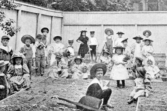 A black-and-white historical photo of young children in a classroom.