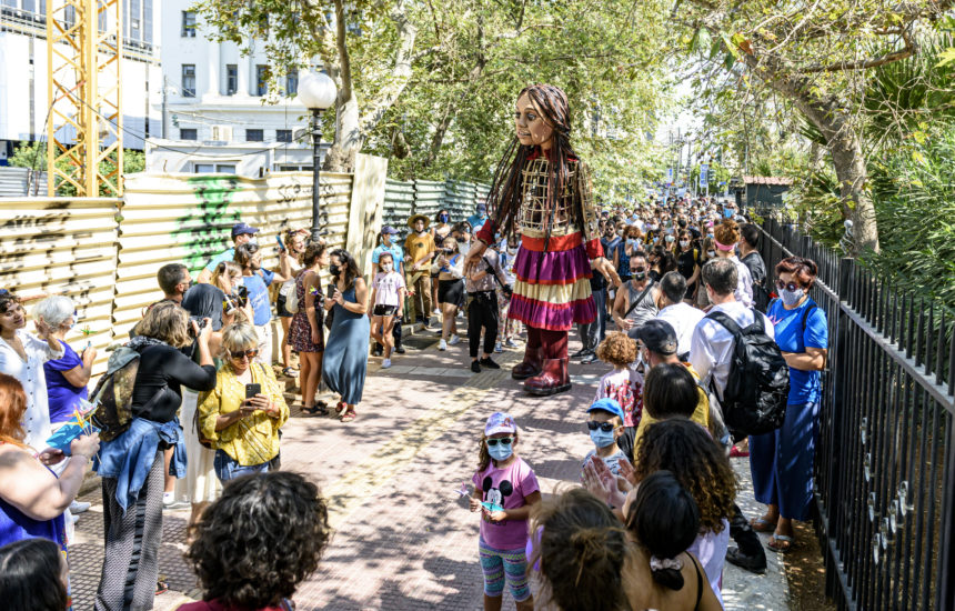 Celebration happening outside featuring a large costumed figure of a woman