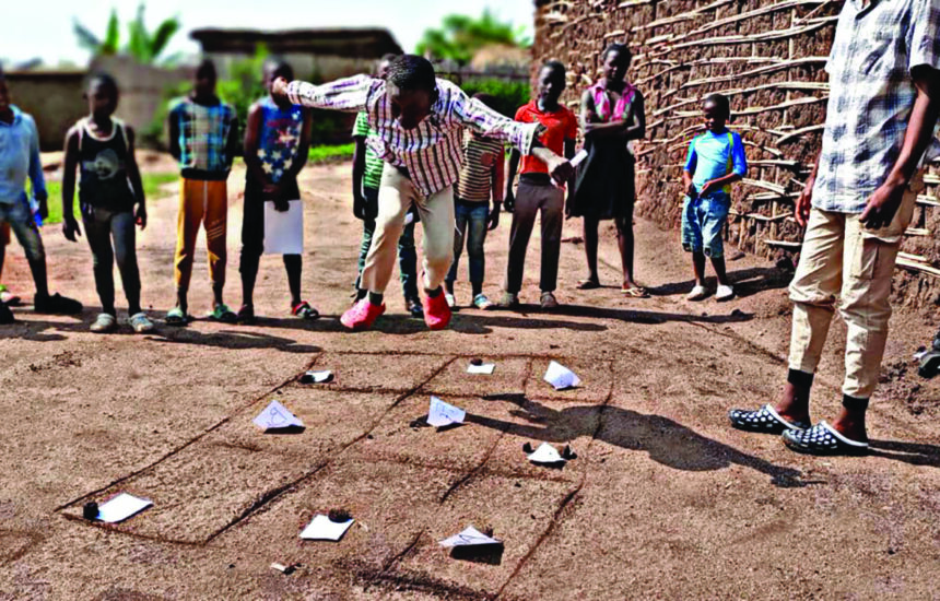 Refugee children in school yard participating in active literacy activity