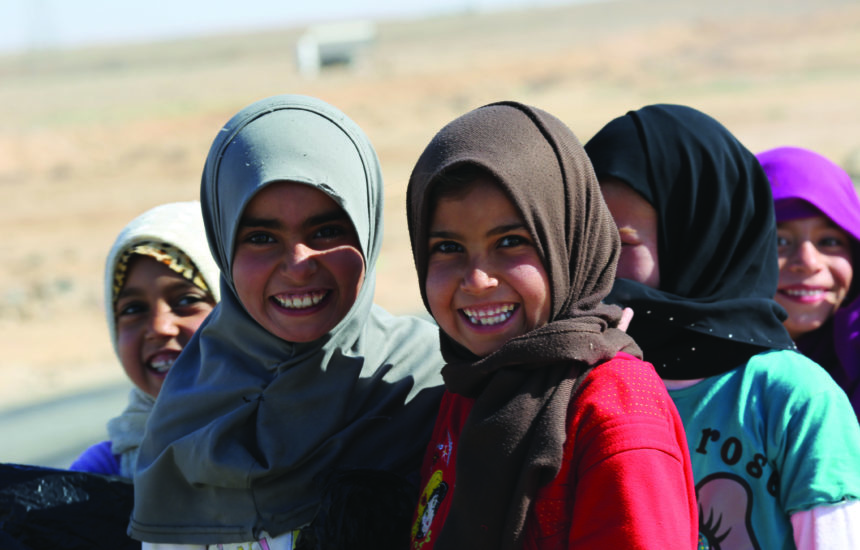 Children wearing hijabs and smiling