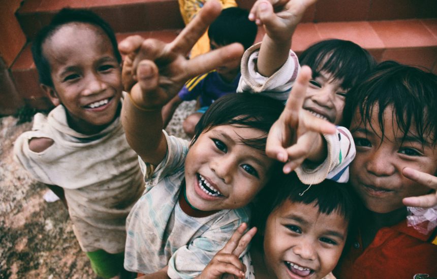 Smiling kids making peace signs with their fingers