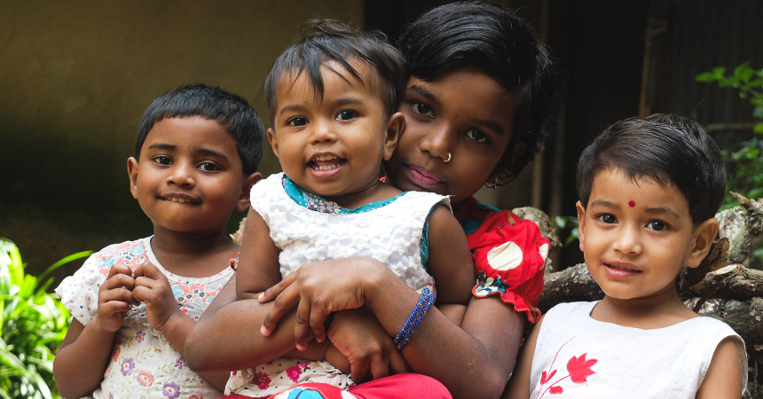 Four smiling young children in Bangladesh.