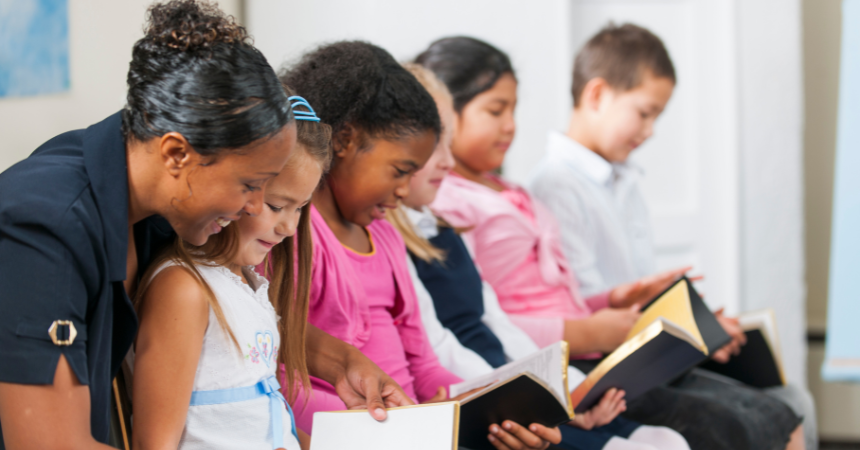 A happy teacher helping students read