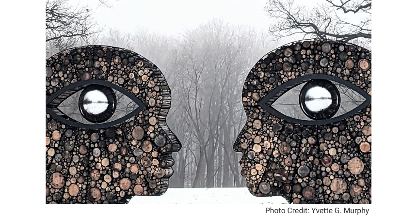 Sculpture of two stone heads in an outdoor area, representing knowledge. Photo Credit: Yvette G. Murphy.