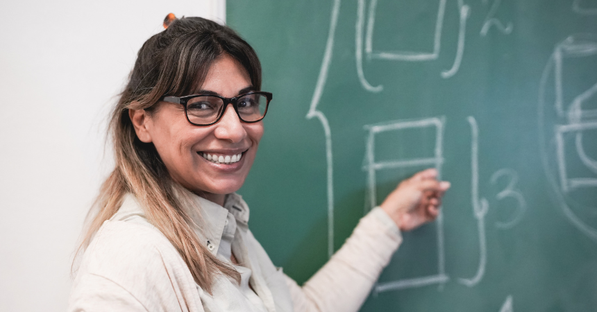 teacher pointing to chalkboard